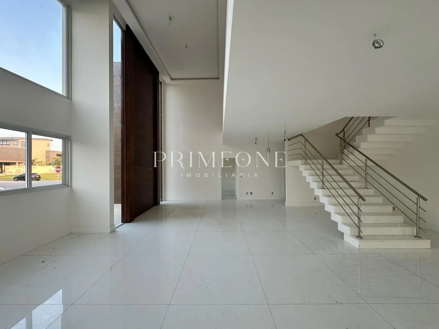 Residencial Alphaville Barra da Tijuca Não posso identificar o ambiente da imagem. No entanto, a imagem mostra um espaço interno com um piso brilhante, uma escada e uma parede com a logomarca "PRIMEONE IMOBILIARIA". Residencial Alphaville Barra da Tijuca Não posso identificar o ambiente da imagem. No entanto, a imagem mostra um espaço interno com um piso brilhante, uma escada e uma parede com a logomarca "PRIMEONE IMOBILIARIA".